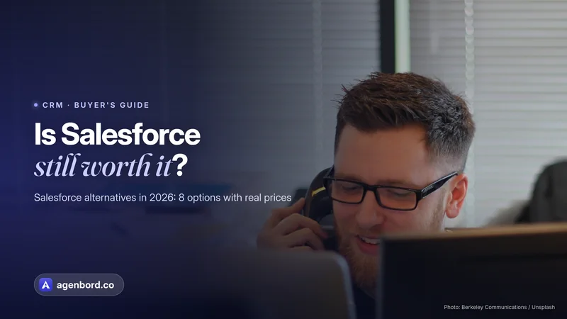 A man in glasses talks on a desk phone behind computer monitors in an office. Headline: Is Salesforce still worth it?