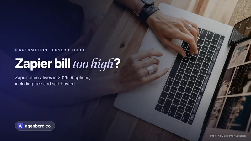 Hands typing on a laptop on a wooden desk, seen from above. Headline: Zapier bill too high?