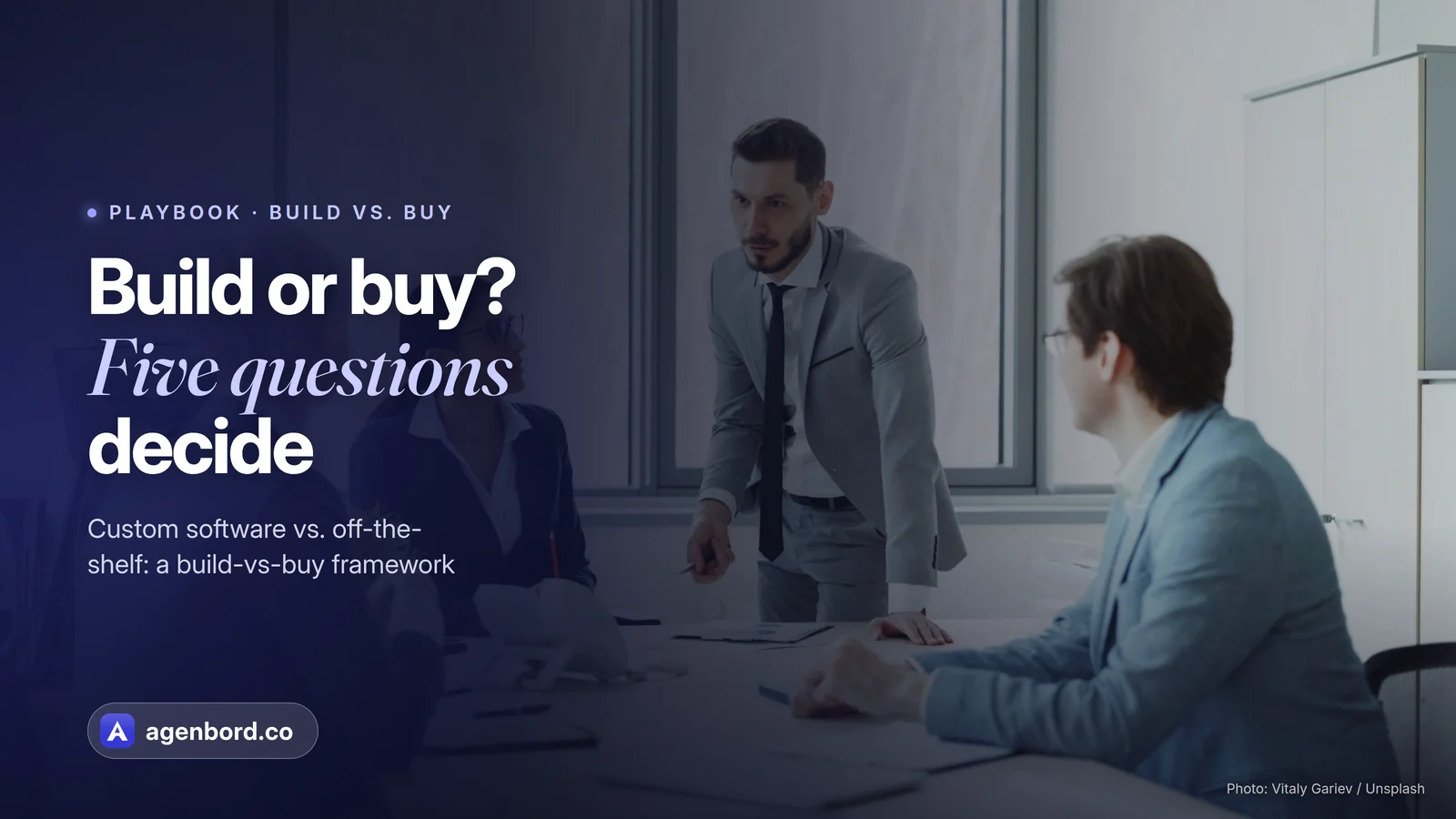 Colleagues weighing options in a meeting around a table. Headline: Build or buy? Five questions decide