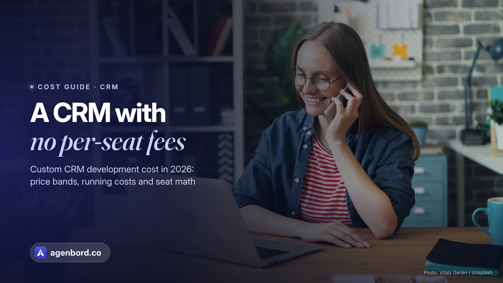 A woman on a phone call while working on a laptop in an office. Headline: A CRM with no per-seat fees